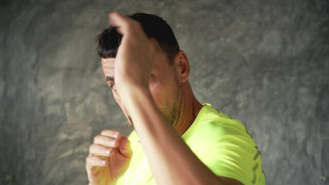 A man at home trains shadow boxing. Beats punches and elbows. Boxing and Muay Thai training .