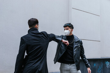 two men greeting each other with masks