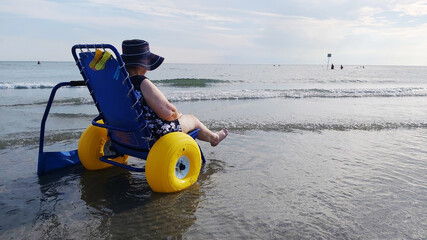 disabled senior lady on a special wheelchair to the beach