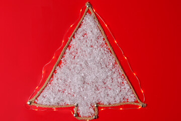 Top view of handmade craft christmas tree made from rope and snow on the red background
