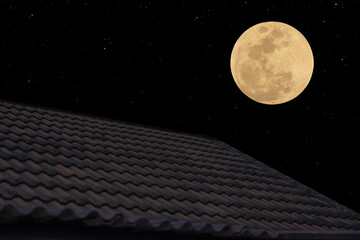 Full moon on the sky over roof tiles.  © Onkamon