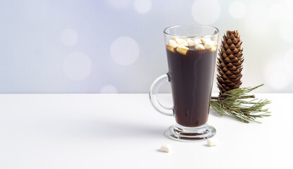 Hot coffe with marshmallows in transparent tall glass, isolated on white background.