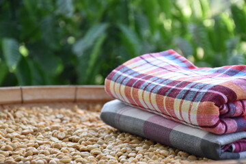 Thaistyle loinclothes on basket of coffee seeds.
