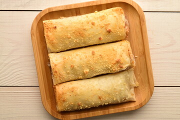 Several mini strudel with an apple, close-up, on a wooden table.