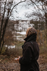 young woman in a leopard scarf in an autumn park and castle