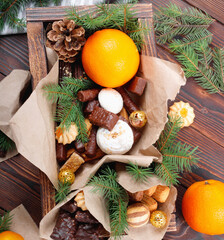 Delicious sweets, chocolates, cookies and oranges for gifts in  wooden box on  vintage table