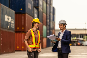 Container yard manager talking to female foreman about custom document of the goods inside the container yard  among containers