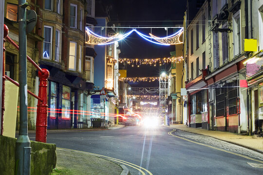 Long exposure image of the small North Devon fishing village of Ilfracombe 'High street' illuminated at dusk with festive christmas lights