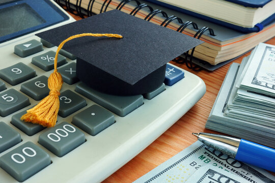 Student loan concept. Graduation cap on the calculator.
