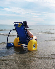 disabled senior lady ona special wheelchair to the beach