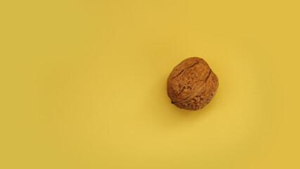 Walnut isolated on a yellow background. Top view