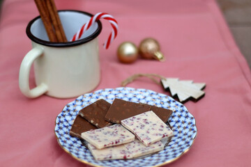 Obraz na płótnie Canvas Chocolate pieces, vintage dishes and Christmas decorations. Selective focus, pink background. 