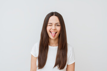 Close up photo of cute attractive young woman isolated on white background. Show tongue.