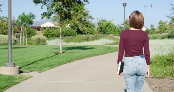 Young Woman Walking on a Path Through a Park