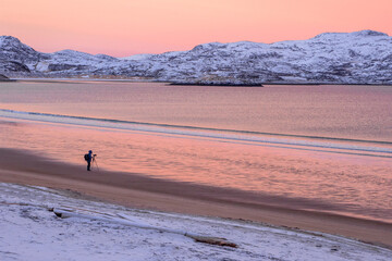 The photographer shoots a wonderful Arctic sunset landscape on the Barents sea
