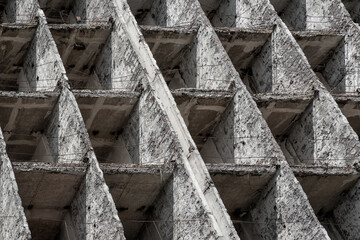 Full-screen background - fragment of the facade of a concrete dilapidated building with square cells, diagonal composition