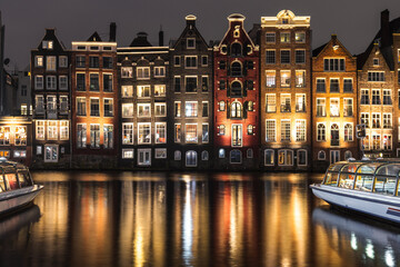 Obraz premium Amsterdam's houses near the canal at night.