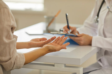 Close up of hands of doctor and patient discussing diagnosis sitting in hospital office