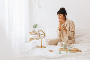 Young woman applying face cream