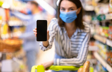 Woman In Mask Holding And Showing Smartphone With Blank Screen