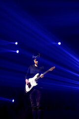 A musician man playing the Guitar on the stage with beautiful blue lighting
