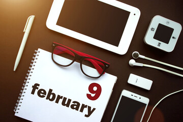 February 9th. Day 9 of month, Calendar date. Office workplace with laptop, notebook, office...