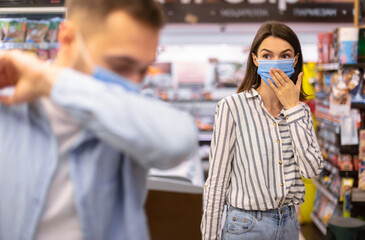 Sick Man Coughing In Elbow, Scared Woman Looking At Him