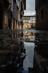 reflejo de los edificios en un charco de la Zona antigua de Hondarribia. Basque country 