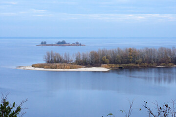 An island among the Dnieper river on a cloudy day. Autumn dull landscape. Travel by Ukraine.