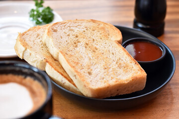 Close-up view, Whole wheat toast in black plate with juicy red sauce.