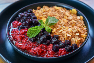 Close-up view, Granola with Berries in a black plate.