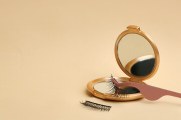 Magnetic eyelashes and accessories on beige background. Space for text