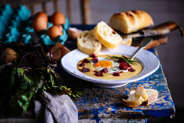 Cream of potato soup with beetroot and fried eggs.style rustic.