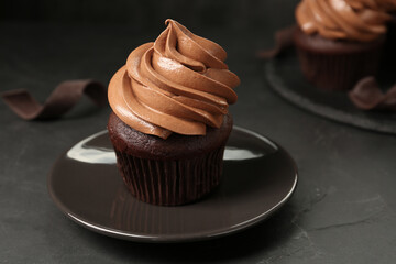 Delicious fresh chocolate cupcake on black slate table, closeup