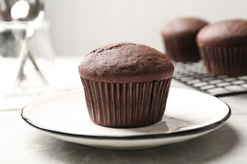 Delicious chocolate cupcake on light grey marble table, closeup