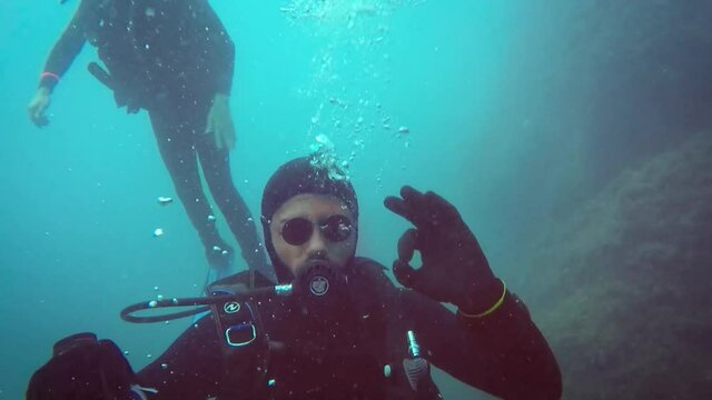 Buceador se pone gafas de sol debajo del agua en el mar