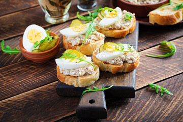 Toasted bread with a salted codfish mousse on wooden cutting board. Mackerel paste on toasts from fried bread.  Scandinavian cuisine