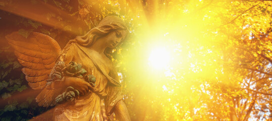 Guardian angel statue in sunlight. Horizontal image.