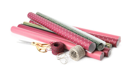 Different colorful wrapping paper rolls, scissors and ropes on white background
