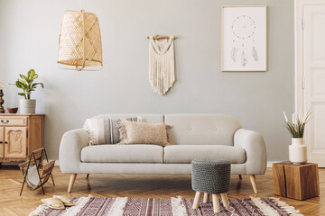 Modern concept in design home interior with grey sofa, coffee table, macrame, plants, carpet and elegant accessories. Stylish and minimalistic home decor. Template.