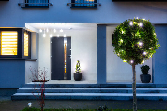 House entrance illuminated by christmas lights at night