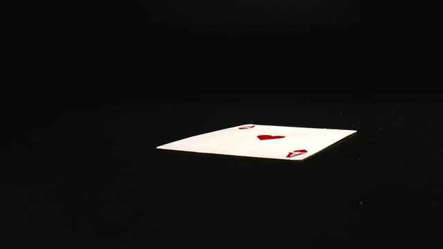 Falling Ace of hearts, playing cards, on black table. Honour cards Close-up. Gambling club concept. High quality