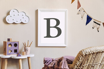 Stylish scandinavian nursery interior with mock up photo frame, toy, design furniture, pillows and accessories. Beautiful decoration on the beige background wall. Home decor for children room.