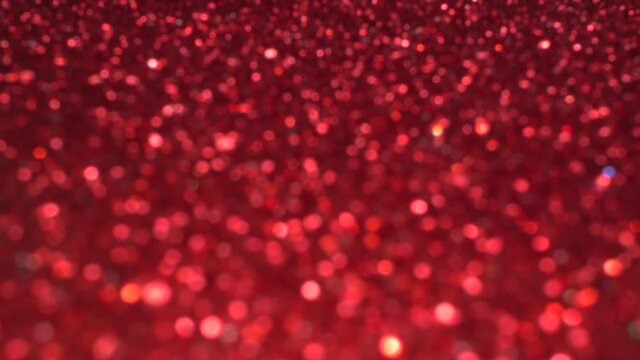 Brilliant background for Christmas and new year holiday. Red moving shiny sequins rhinestones and particles create a beautiful magic bokeh