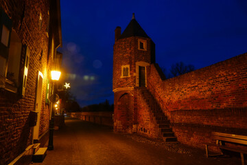 Straße und Stadtmauer mit Turm in der Zollfeste Zons bei Nacht