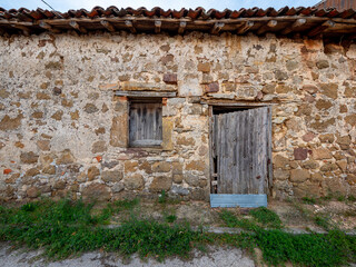 Facade of an old house in a town in Castilla y Leon Spain, wooden doors and stone facade.