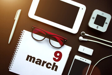 March 9th. Day 9 of month, Calendar date. Office workplace with laptop, notebook, office supplies...
