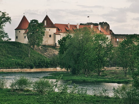 

View to the Bauska Castle  with the river Memele in foreground on bright a summer day in Bauska, Latvia
