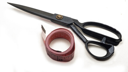 A scissor and sewing measuring tape on an isolated white background. Sewing tools and equipments. Cloth fashion concept.