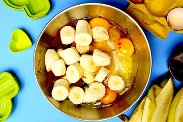 top view of unmixed sponge cake mix surrounded by baking or pastry molds. home cooking concept.